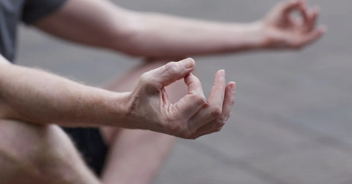Manos en posición de meditación apoyadas sobre las rodillas