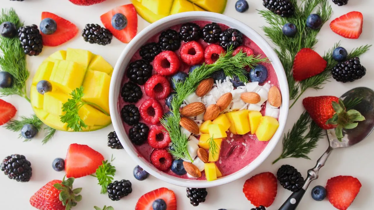 Bowl de yogur con frutos rojos, mango, almendras y coco